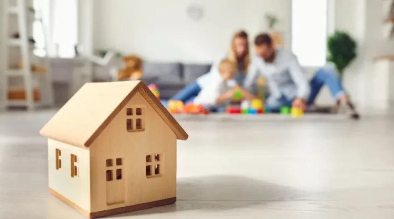 Petite maison de bois dans un salon avec une famille qui a pris une hypothèque pour auto-constructeurs